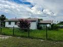 White house with a large yard, wooden fence, and satellite dish at 708 Lake Shore Dr, Pierson, FL 32180