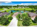 Aerial view of a single-Gathering home with a pond and lush landscaping in a residential community at 30115 Kladruby Pt, Mount Dora, FL 32757