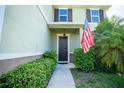 Inviting front entrance with dark brown door and lush landscaping at 11430 Wishing Well Ln, Clermont, FL 34711