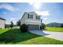 Two story house with a two car garage and landscaped lawn at 11430 Wishing Well Ln, Clermont, FL 34711