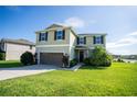 Two story house with a two car garage and landscaped lawn at 11430 Wishing Well Ln, Clermont, FL 34711