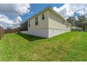 View of the house's side and backyard, showing ample green space at 11394 Zimmerman Path, Oxford, FL 34484