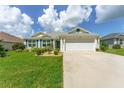 House exterior featuring a two-car garage and well-manicured lawn at 11394 Zimmerman Path, Oxford, FL 34484