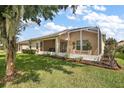 Backyard screened porch with lush landscaping at 27227 Roanoke Dr, Leesburg, FL 34748