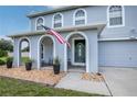 Front entrance with arched entryway, porch, and landscaping at 7425 Lake Marni Ct, Mount Dora, FL 32757