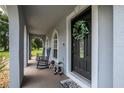 Covered porch with rocking chairs and a welcoming entry door at 7425 Lake Marni Ct, Mount Dora, FL 32757