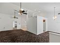 Spacious living room with high ceilings, ceiling fans, and dark brown carpet at 36649 Sundance Dr, Grand Island, FL 32735