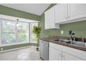 Kitchen with white cabinets, stainless steel dishwasher, and granite countertops at 1500 Cobble Ln, Mount Dora, FL 32757