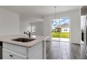 Kitchen with island, sink, and view of backyard through sliding doors at 512 Silver Palm Dr, Haines City, FL 33844