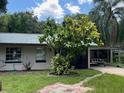 One-story home with a green metal roof and lush landscaping at 951 Cr 482B, Lake Panasoffkee, FL 33538