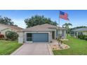 House exterior, gray with blue garage door, American flag at 32915 Crooked Oaks Ln, Leesburg, FL 34748