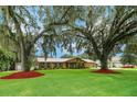 Yellow ranch home with red roof and manicured lawn at 2334 Lake Griffin Rd, Lady Lake, FL 32159