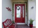 Red front door with a wreath and sidelights, welcoming entryway at 1199 Playa Del Sol Ln, Saint Cloud, FL 34771