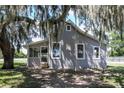 House exterior with a screened porch and large oak tree at 19402 E 5Th St, Umatilla, FL 32784