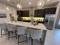 Modern kitchen with dark cabinetry, granite countertops, and stainless steel appliances at 10068 Fiddley Aly, Orlando, FL 32827