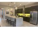 Modern kitchen with dark cabinetry, granite countertops, and stainless steel appliances at 10068 Fiddley Aly, Orlando, FL 32827