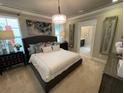 Spacious main bedroom with plush carpeting, large bed, and en-suite bathroom at 10068 Fiddley Aly, Orlando, FL 32827