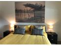 Primary bedroom with large bed, nightstands and ocean art at 124 Orange Ave, Clermont, FL 34711