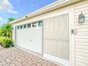 White garage with screen door and brick pavers at 1502 Barrera Ct, The Villages, FL 32159