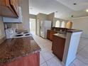 Kitchen with granite countertops, wooden cabinets, and white appliances at 390 Colonade Ct, Kissimmee, FL 34758