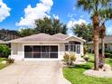 Single-story home with attached garage, landscaped yard, and palm trees at 4706 Glen Coe St, Leesburg, FL 34748