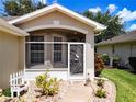 Front entrance with screened porch and decorative iron gate at 4706 Glen Coe St, Leesburg, FL 34748
