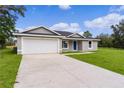 Single story home with attached garage and driveway at 5 Malauka Radial Run Rd, Ocklawaha, FL 32179