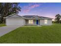 Single story home with attached garage and landscaped lawn at 5 Malauka Radial Run Rd, Ocklawaha, FL 32179