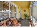 Relaxing front porch with wicker furniture and screened enclosure at 1213 El Esparza Ln, The Villages, FL 32159