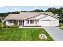 House exterior with two-car garage, landscaping, and American flag at 6401 Tildon, Leesburg, FL 34748