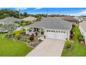 House exterior featuring a landscaped yard and white garage door at 5452 Zajac Ave, The Villages, FL 32163