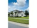 Two-story house with tan siding, stone accents, and a walkway at 2157 Valencia Blossom St, Clermont, FL 34711