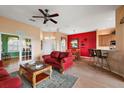 Living room with red couches, wood floors, and view of the lanai at 17739 Se 121St Terrace Rd, Summerfield, FL 34491