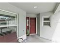 Front porch with seating, red door and view of the neighborhood at 2968 Wotring Way, The Villages, FL 32163