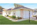 Home exterior showing side view and garage at 21701 Queen Mary Ct, Leesburg, FL 34748