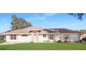 Single-story home with pink accents and green lawn at 21701 Queen Mary Ct, Leesburg, FL 34748