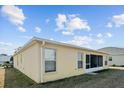 Rear view of a tan house with a screened porch and windows at 15300 Sw 14Th Avenue Rd, Ocala, FL 34473