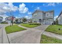 A gray two-story house with a paved driveway at 1592 Flange Dr, Davenport, FL 33896