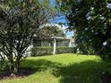 Landscaped backyard with lush greenery and a view of the home's screened patio at 2277 Calvert Ct, Clermont, FL 34711