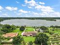 Lakefront property showcasing a spacious house and lush green surroundings at 2405 Morningside Dr, Mount Dora, FL 32757