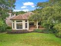 Spacious covered patio with brick flooring and lush landscaping at 9323 San Jose Blvd, Howey In The Hills, FL 34737