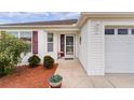 Inviting front entrance with a glass door and landscaping at 2403 Carriage Hill Way, The Villages, FL 32162