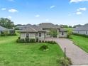 Single-story home with a landscaped lawn and paver driveway at 5159 Greens Dr, Lady Lake, FL 32159
