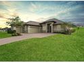 Single-story home with a two-car garage and landscaped lawn at 5159 Greens Dr, Lady Lake, FL 32159