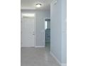 Entryway with tile flooring, leading to laundry room and front door at 3654 Caspian St, Leesburg, FL 34748