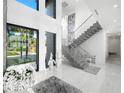 Bright entryway with modern staircase and views to backyard at 15617 Pendio Dr, Bella Collina, FL 34756