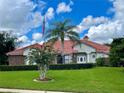 One-story home with red tile roof, brick facade, and manicured lawn at 39331 Treeline Dr, Lady Lake, FL 32159