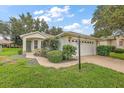 Brick ranch home with a two-car garage and landscaped yard at 5206 Fantasy Way, Leesburg, FL 34748