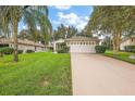 Brick ranch home with a two-car garage and landscaped yard at 5206 Fantasy Way, Leesburg, FL 34748