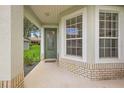 Inviting front porch with a green door and large windows at 5206 Fantasy Way, Leesburg, FL 34748